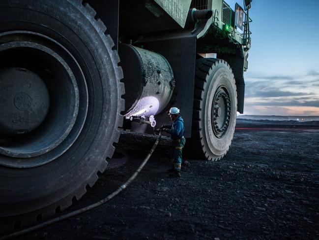 A worker wears a headlight while refueling a dump truck at the Tavan Tolgoi coal deposit developed by Erdenes Tavan Tolgoi JSC, a unit of Erdenes Mongol LLC, in Tsogtsetsii, Ömnögovi Province, Mongolia, on Monday, Sept. 24, 2018. Mongolia has expanded its coal reserves by 24 percent at the state-owned giant Tavan Tolgoi mine to 6.34 billion tons, according to Erdenes Tavan Tolgoi Chief Executive Officer Gankhuyag Battulga. Mongolian lawmakers in June approved a plan to sell up to 30% of the coal mine in the Gobi desert, the latest attempt to develop what's anticipated to be massive coking and thermal coal deposit. Photographer: Taylor Weidman/Bloomberg