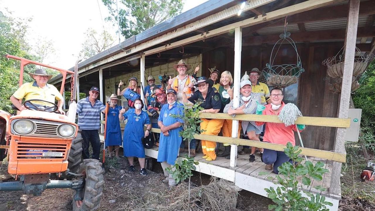 FCRC CEO Ken Diehm (centre with hat) and volunteers combine to clean up the residence of Ian Perrett, 84, whose historic home suffered damage in the recent flood. PHOTO: Robyne Cuerel