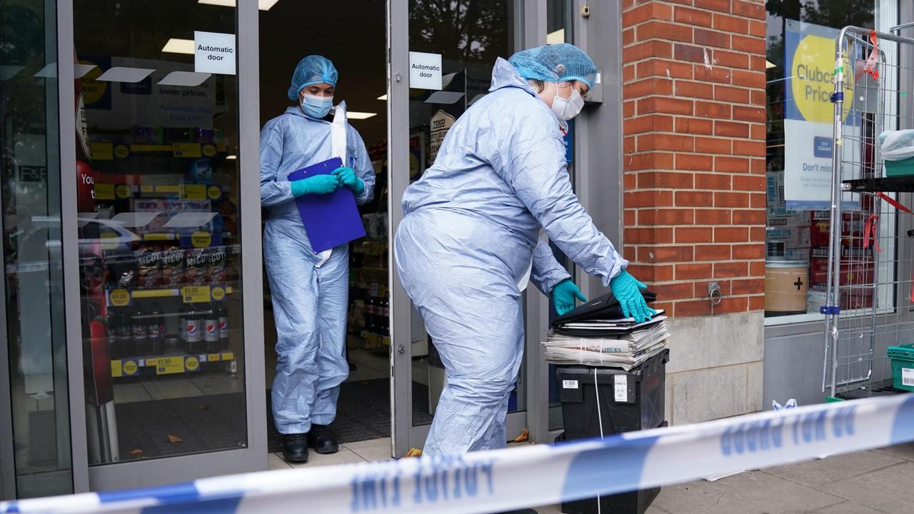 Police officers in forensic suits outside Tesco Express on Fulham Palace Road. Picture: Jonathan Brady/PA Wire