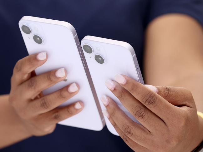 CUPERTINO, CALIFORNIA - SEPTEMBER 07: An Apple employee holds a new iPhone 14 and iPhone 14 Plus during an Apple special event on September 07, 2022 in Cupertino, California. Apple unveiled the new iPhone 14 as well as new versions of the Apple Watch, including the Apple Watch SE, a low-cost version of the popular timepiece that will start st $249.   Justin Sullivan/Getty Images/AFP