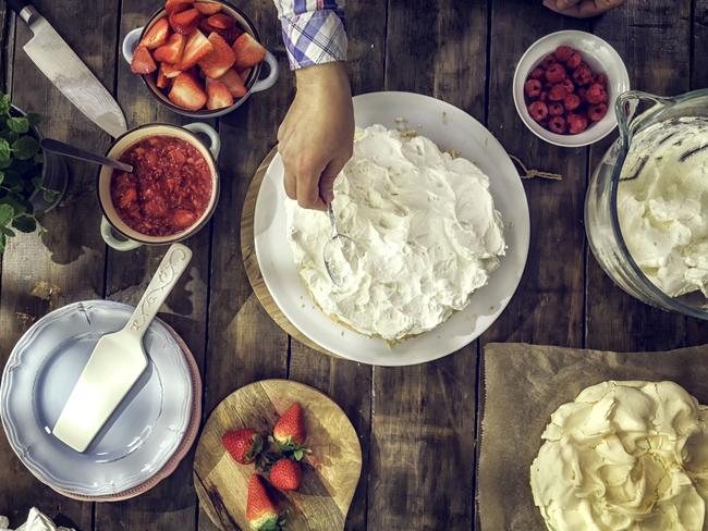 Prepare your pavlova with fresh strawberries, raspberries, mint leaves and whipped cream.