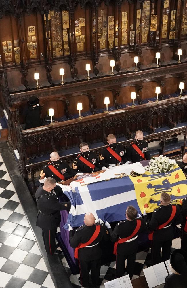 The Queen watches as pall bearers place the coffin of the Duke of Edinburgh during his funeral. Picture: Jonathan Brady – WPA Pool/Getty