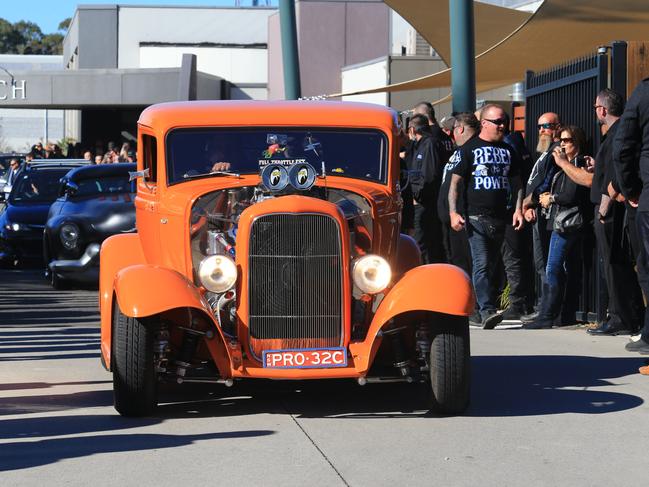 A bright orange hot rod leaves the church. Picture: Adam Taylor