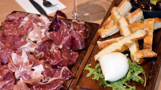 Antipasto della casa features buffalo mozzarella, homemade focaccia bread, Sicilian green olives, Kalamata black olives, beef bresaola, salami and prosciutto.