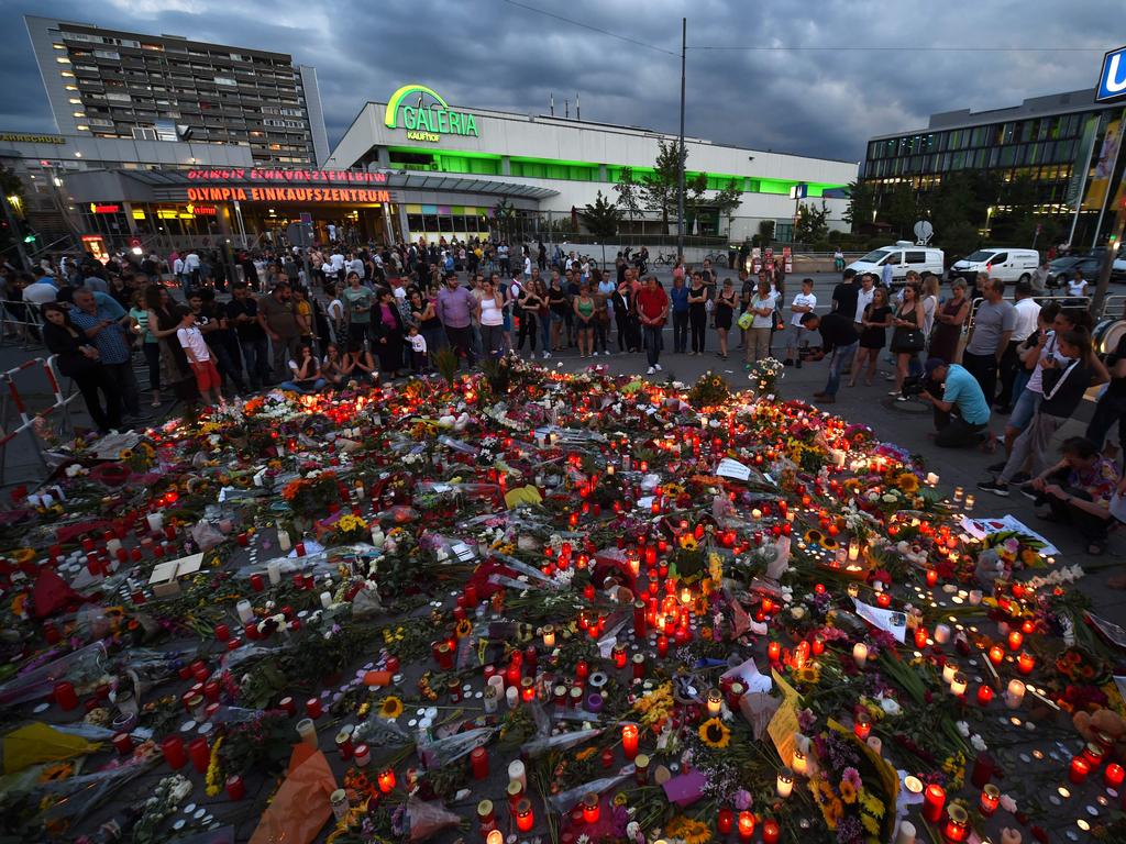 People mourn in front of candles and flowers on July 24, 2016 in front of the Olympia Einkaufszentrum shopping centre in Munich, southern Germany, where an 18-year-old German-Iranian student run amok. Europe reacted in shock to the third attack on the continent in just over a week, after David Ali Sonboly went on a shooting spree at a shopping centre on July 22, 2016 in what appears to have been a premeditated attack, before turning the gun on himself. Picture: AFP PHOTO / CHRISTOF STACHE