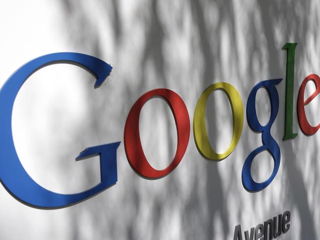 In this June 5, 2014 photo, a man walks past a Google sign at the company's headquarters in Mountain View, Calif. Google is buying Skybox Imaging in a deal that could serve as a launching pad for the Internet company to send its own fleet of satellites to take aerial pictures and provide online access to remote areas of the world. (AP Photo/Marcio Jose Sanchez)