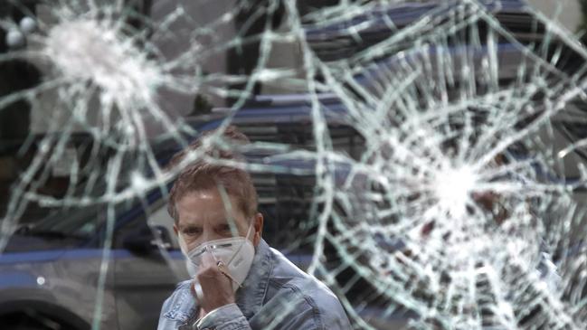 A woman looks at a smashed storefront window in Boston's Downtown Crossing. Picture: AP Photo/Elise Amendola