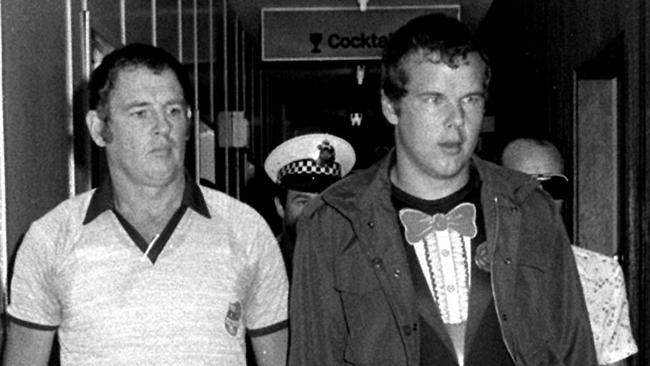 Murderer Andy Albury is led by detectives through Darwin Airport in 1984.