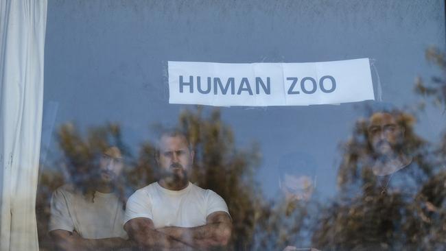 Detainees inside the hotel placed signs in their windows as rallies broke out to free the group in January 2022. Picture: NCA NewsWire / Luis Enrique Ascui