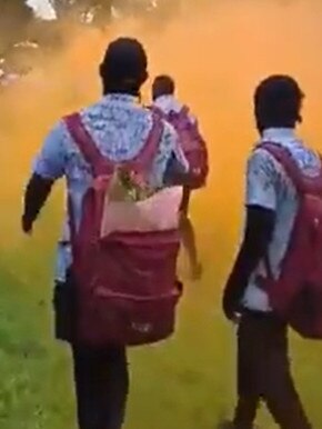 Students walk through smoke from flares. Picture: Twitter