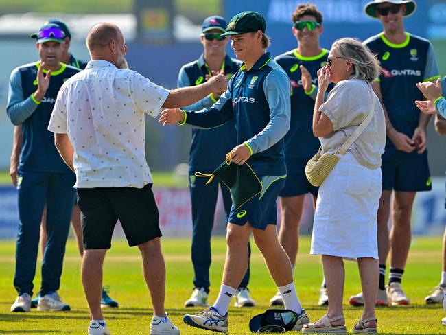 Cooper Connolly with his proud parents shortly after receiving his baggy green cap from Simon Katich Picture: AFP