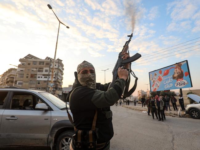 A Syrian anti-government fighter fires his rifle into the air in the streets of the west-central city of Hama. Picture: AFP