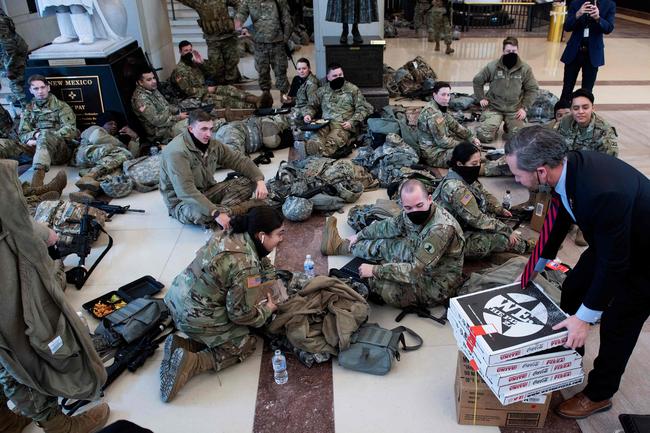 Members of the National Guard receive food in the Capitol Visitors Center on Capitol Hill in Washington, DC, January 13, 2021, ahead of an expected House vote impeaching US President Donald Trump. - The Democrat-controlled US House of Representatives on Wednesday opened debate on a historic second impeachment of President Donald Trump over his supporters' attack of the Capitol that left five dead.Lawmakers in the lower chamber are expected to vote for impeachment around 3:00 pm (2000 GMT) -- marking the formal opening of proceedings against Trump. (Photo by Brendan Smialowski / AFP)