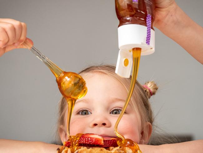 Bega Cheese are helping to save Australian bees from the deadly impacts of Varroa Destructor disease - they are moving away from cheese for the first time and making and selling honey. Molly Ingram, 3 enjoys honey on her waffle. Picture: Jake Nowakowski