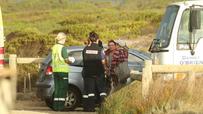 Paramedics talk to witnesses at the accident scene. Picture: Alan Barber