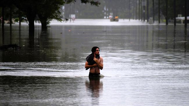 A young man walks through flood waters in Ingham. Picture: Cameron Bates