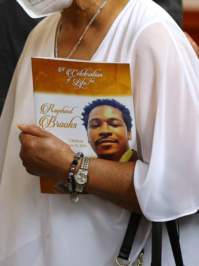 A family member carries the program for Rayshard Brooks funeral on Tuesday in Atlanta. Picture: AFP