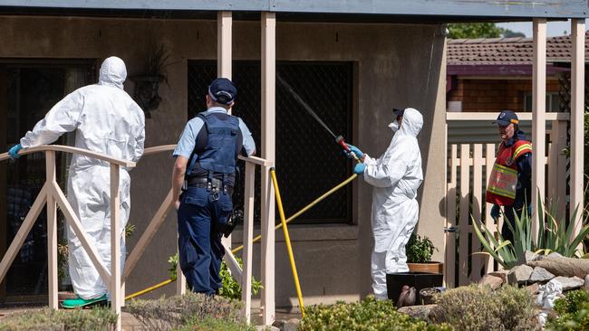 NSW Fire and Rescue officers clearing up the crime scene at the house in Glen Innes on Sunday observed by a NSW police officer. Picture: Julian Andrews