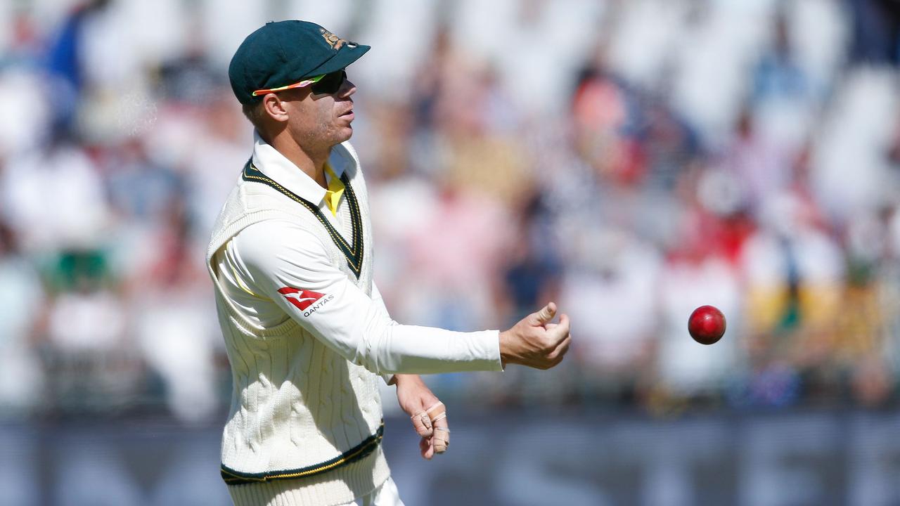 David Warner passes the ball during the fourth day of the third Test cricket match between South Africa and Australia at Newlands cricket ground on March 25