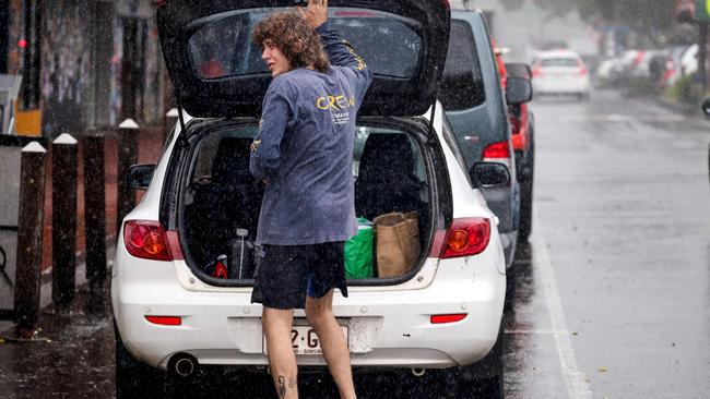 A resident packs a car of stock from a shop in the town of Lismore on March 5, 2025. A rare tropical cyclone veered towards Australia's densely populated eastern coast on March 5, forcing scores of schools to close as worried residents stripped supermarket shelves bare. (Photo by DAVID GRAY / AFP)