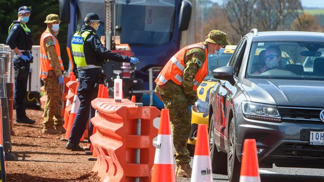 Police and troops check motorists passing through the regional checkpoint on the Calder Freeway, north of Melbourne, on Wednesday. Picture: Jay Town