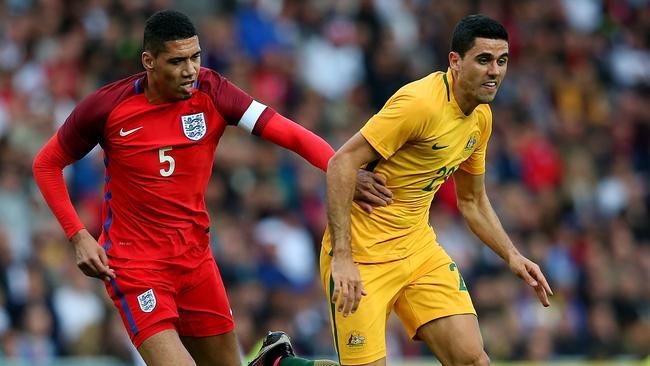 Tom Rogic holds off pressure from Chris Smalling.