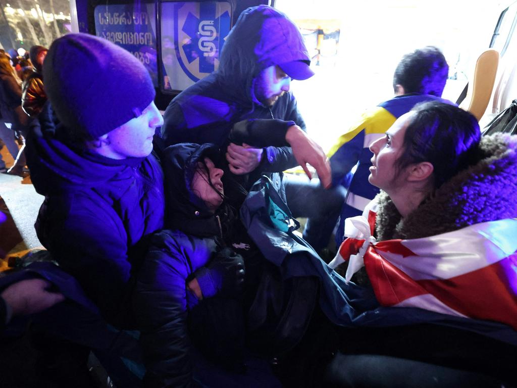 A young woman is helped into an ambulance after becoming injured during the clashes. Picture: Giorgi ARJEVANIDZE / AFP