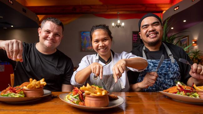 Hidden Valley Tavern’s Jason Sleigh, Joy Ontic and Carmelo Jr Liceralde tuck into their award-winning schnitzel. Picture: Che Chorley