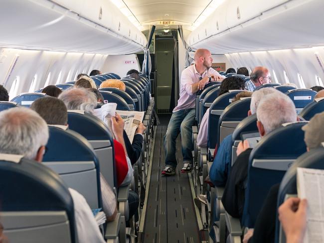 Paris, France- May 13, 2014: Travelers are sitting during the flight and relax reading newspaper.