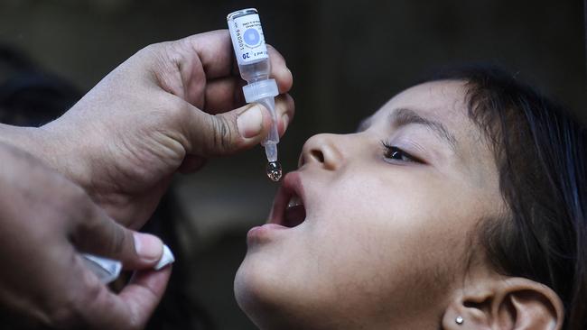 A health worker administers polio vaccine drops to a child. Officials have warned that polio poses its greatest threat for years, blaming delays in getting children vaccinated during the pandemic and the general rise of anti-vaxxers. Picture: AFP