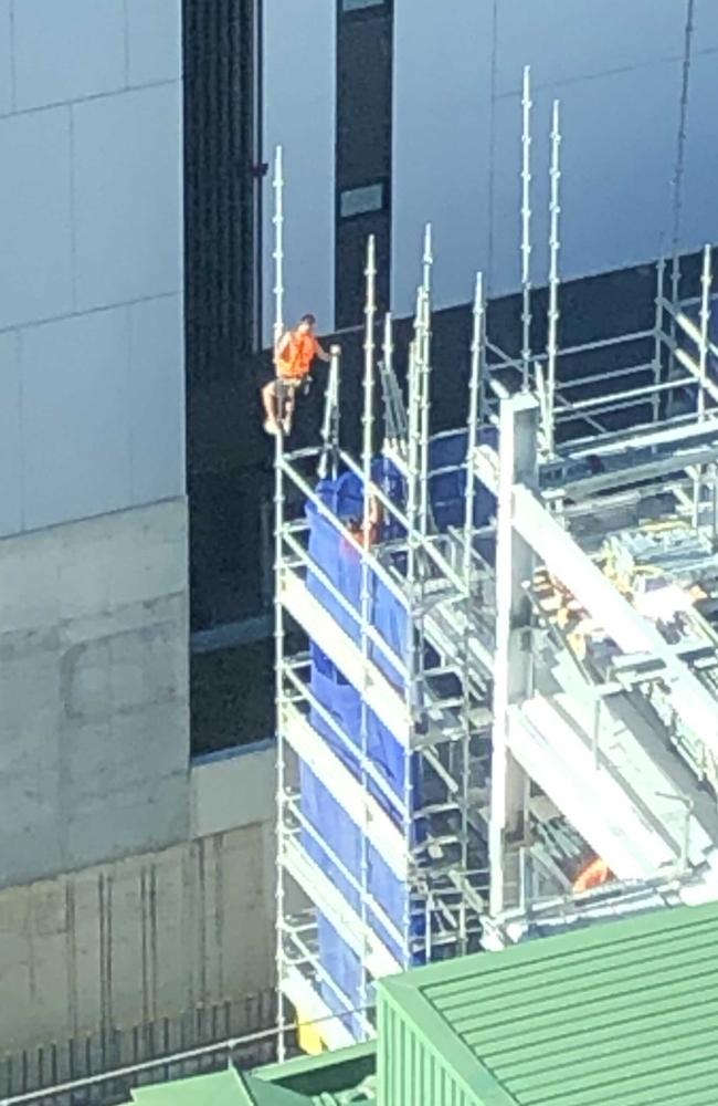 The tradie hanging onto scaffolding, allegedly without a harness, at a work site in Parramatta. Picture: Supplied