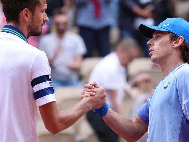 Australia's Alex De Minaur (R) shakes hands with Russia's Daniil Medvedev after winning at the end of their men's round of sixteen singles match on Court Suzanne-Lenglen on day nine of the French Open tennis tournament at the Roland Garros Complex in Paris on June 3, 2024. (Photo by ALAIN JOCARD / AFP)