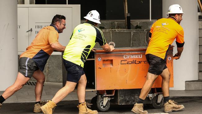 Workers leave the Probuild worksite on 443 Queens Street. Picture: Zak Simmonds