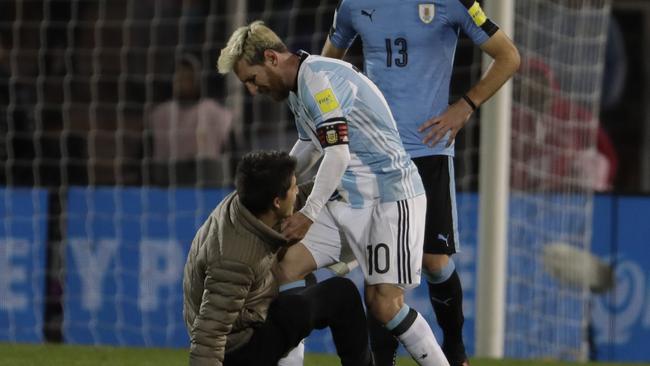 Argentina's Lionel Messi holds a fan who entered the field to touch him during a 2018 World Cup qualifying soccer match against Uruguay in Mendoza, Argentina, Thursday, Sept. 1, 2016.(AP Photo/Natacha Pisarenko)