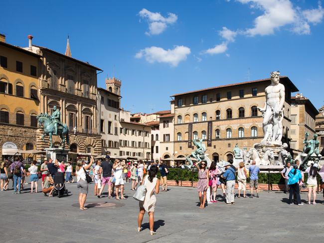 FLORENCE, ITALY - July 28, 2015: Piazza della Signoria, or Signoria Square, in Florence, Italy taken during the summer and showing tourists, the Fountain of Neptune, and other historic statues and buildings. The square is a focal point of the city and a meeting place for Florentines and tourists alike.