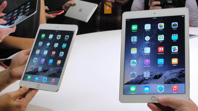 People look at the new iPad Mini 3 (L) and iPad Air 2 (R) on October 16, 2014 during an event unveiling the company's new iPad line in Cupertino, California. Apple released the new iPads and introduced updated operating software and announced that its new mobile payments system, Apple Pay, will launch on October 20. Apple, which popularized tablets with its iPad, remained the largest single global vendor in the second quarter but its market share fell to 26.9 percent from 33 percent in 2013. AFP PHOTO/GLENN CHAPMAN