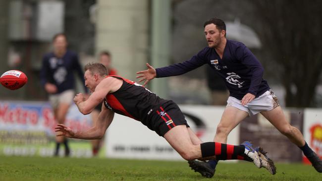 Nathan Buckley shoots out a handball. Photo by Jonathan DiMaggio/Getty Images for Bursty PR