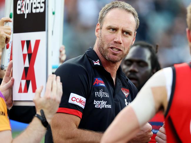 ADELAIDE, AUSTRALIA - MARCH 27: Senior coach Ben Rutten of the Bombers speaks to his players during the 2021 AFL Round 02 match between the Port Adelaide Power and the Essendon Bombers at Adelaide Oval on March 27, 2021 in Adelaide, Australia. (Photo by James Elsby/AFL Photos via Getty Images)