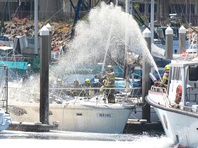 A yacht destroyed by fire while moored near the Sail Master Tavern at North Haven. With the fire almost extinguished, more water is sprayed onto the burnt out hull. 1 February 2025. Picture: Dean Martin