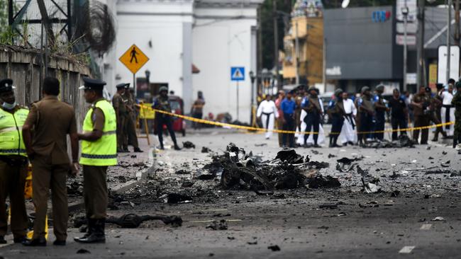 Sri Lankan security inspects debris of a car after it exploded when police tried to defuse a bomb near St Anthony's Shrine in Colombo. Picture: AFP