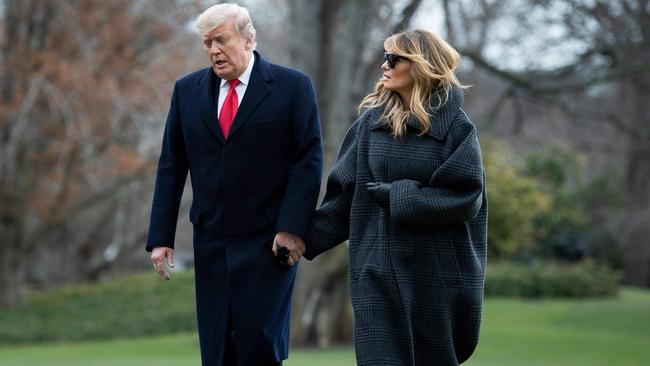 US President Donald Trump and First Lady Melania Trump walk from Marine One as they return to the White House on December 31. Picture: AFP