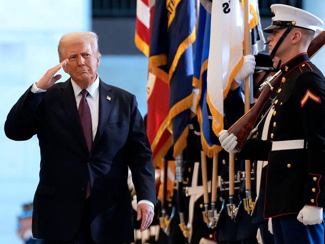 US President Donald Trump salutes troops on his return to the White House on January 20. Picture: AFP