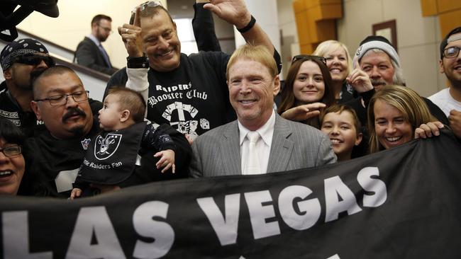 FILE - In this April 28, 2016, file photo, Oakland Raiders owner Mark Davis, center, meets with Raiders fans after speaking at a meeting of the Southern Nevada Tourism Infrastructure Committee in Las Vegas. Nevada lawmakers convene Monday, Oct. 10, 2016, to consider raising taxes in the Las Vegas area to help fund a $1.9 billion football stadium, a $1.4 billion convention center expansion and more police officers to protect the additional tourists. (AP Photo/John Locher, File)