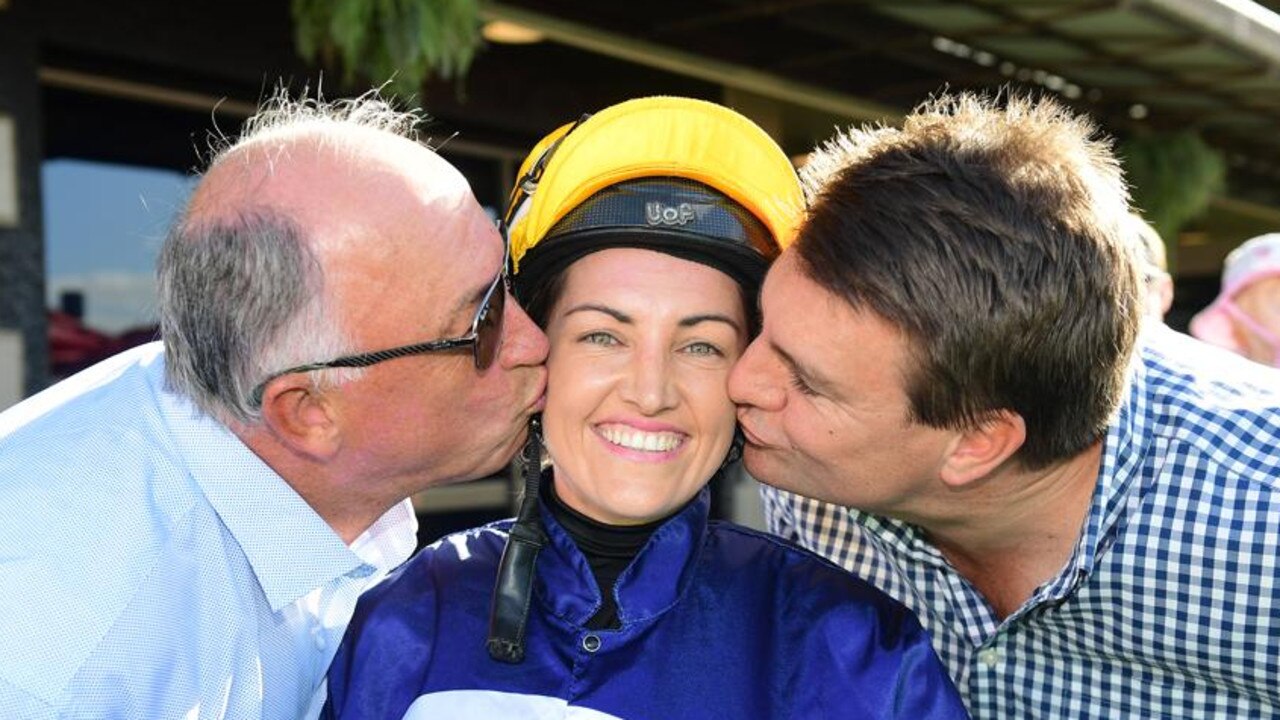 Rob Heathcote and Chris Anderson kiss jockey Tegan Harrison after she rode their first winner, Vienna Moon, to victory at Eagle Farm in May. Picture: Grant Peters, Trackside Photography