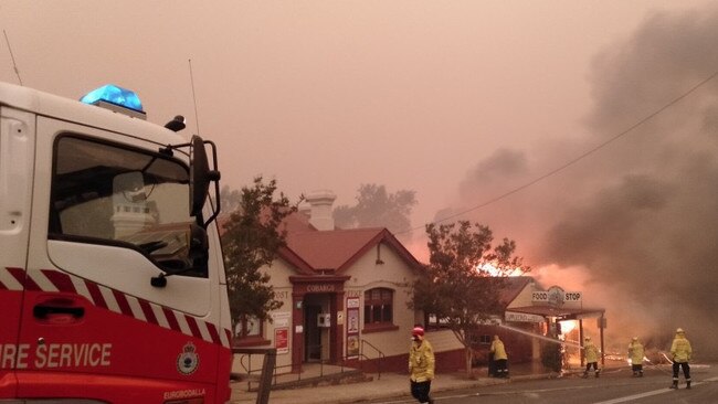 Firefighters defend properties on the main street of Cobargo. Credit: Neil Crawley