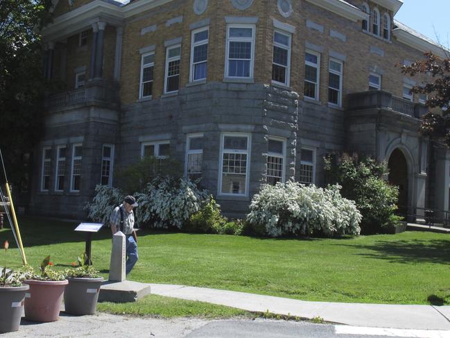 In this photo taken on June 8, 2017 in Derby Line, Vt., a border post and planters show the U.S.-Canadian border where it leads to the Haskell Opera House and library, a building located in the two countries. Brian and Joan Dumoulin, from the nearby neighborhood of Beebe Plain, say they're having a hard time selling their home that straddles the border. (AP Photo/Wilson Ring)