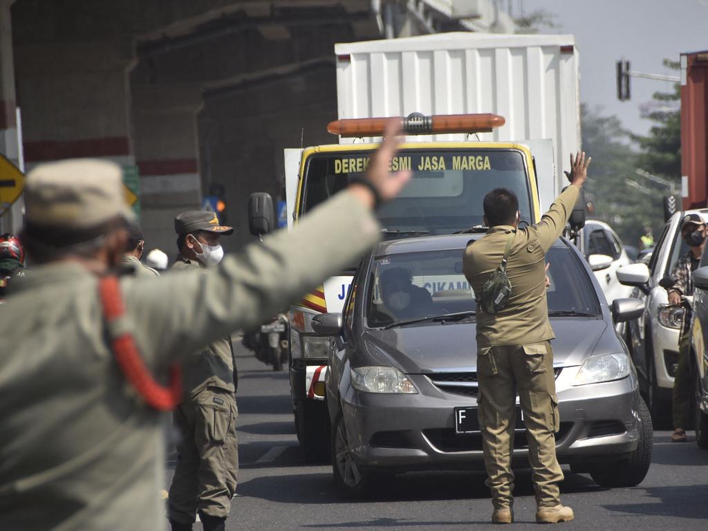 Officials turn back vehicles at the border with Jakarta in Bekasi, West Java on July 3, 2021, as Indonesia ramps up restrictions to combat a surge of Covid-19 infections. Picture: AFP.