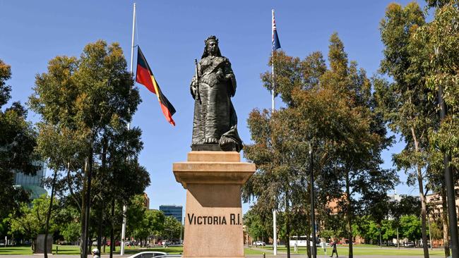 A statue of Queen Victoria in front of the Aboriginal flag at half-mast in Victoria Square. Picture: NCA NewsWire / Brenton Edwards