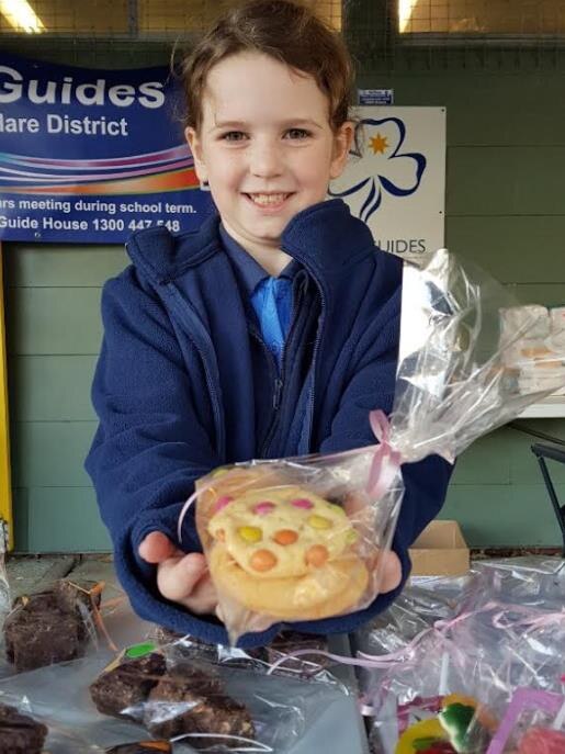 Lily Walsh of Point Clare Junior Guides selling cakes, slices and biscuits from $1