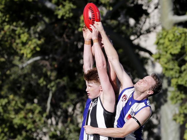 Jack Austin (left) of Western Magpies and Jayden Crawley of Mount Gravatt contest a mark during the QAFL match played at Mount Gravatt, Saturday, April 6, 2019. (AAP Image/Regi Varghese)